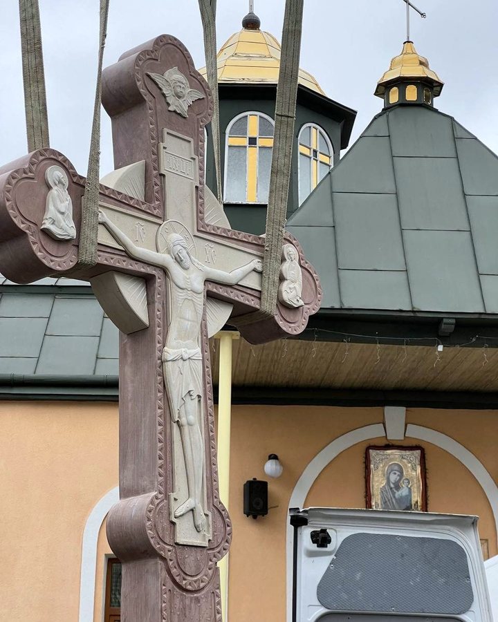Монтаж кам'яного хреста з розп'яттям на стропах біля храму