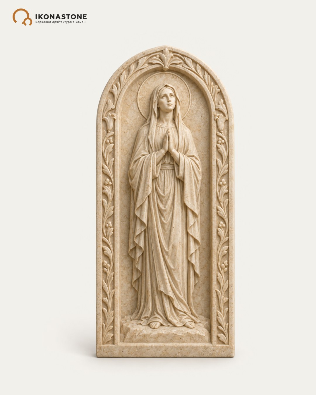 Visualisation: relief icon in cream stone — a haloed female figure in prayer within an arched frame with foliate ornament