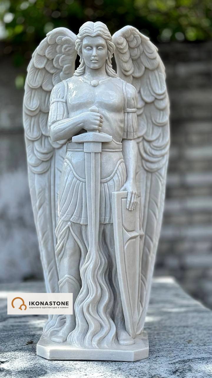 White sculpture of the Archangel Michael with a sword and shield