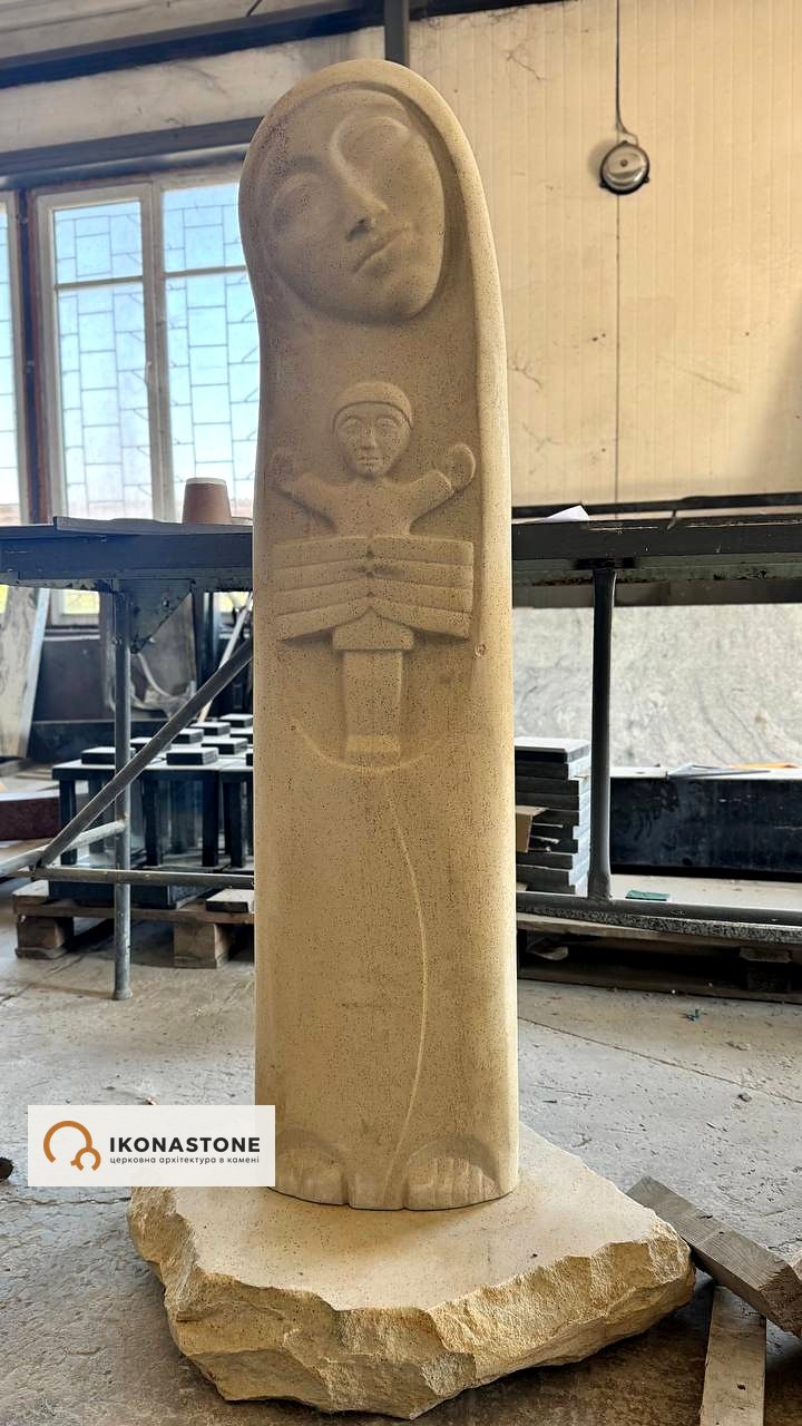 Stone sculpture of the Mother of God with the Child on a rough-split base, in the workshop
